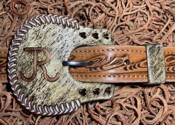 a cow horn buckle with hearts, breads, and copper inlay