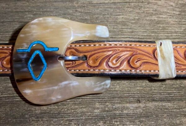 a cow horn buckle with turquoise inlay