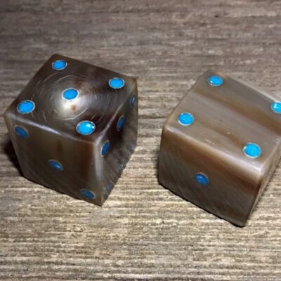 a set of cow horn dice with turquoise dots