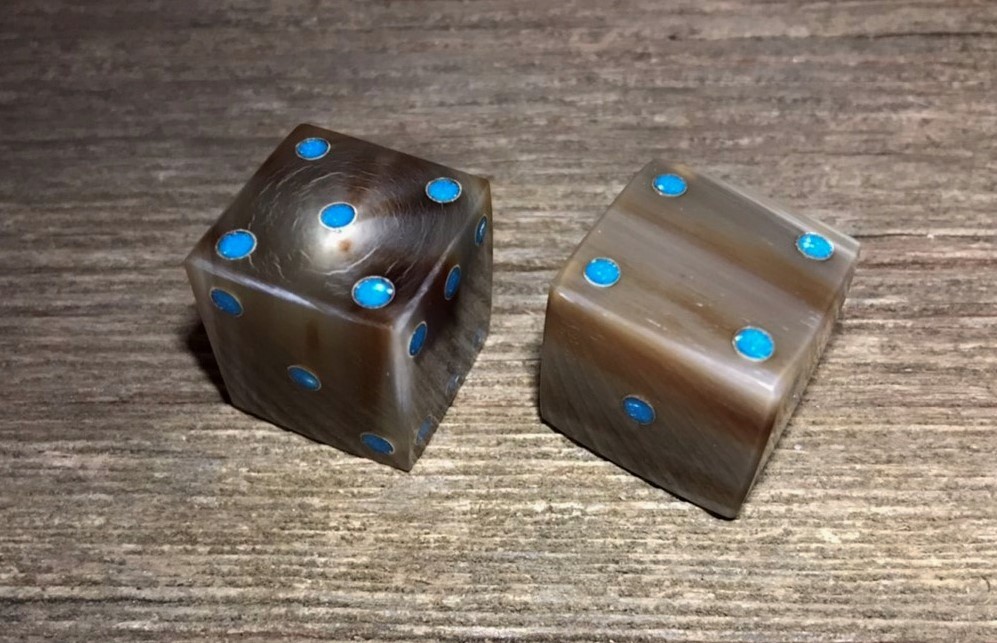 a set of cow horn dice with turquoise dots