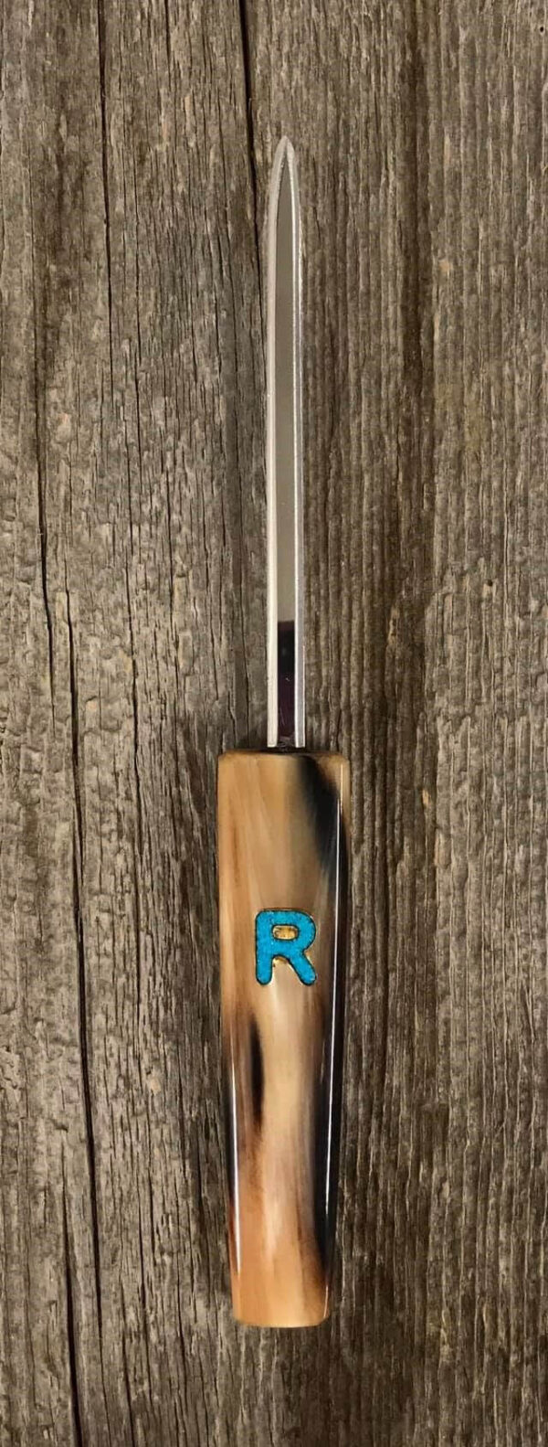 a letter opener with cow horn handle and turquoise inlay