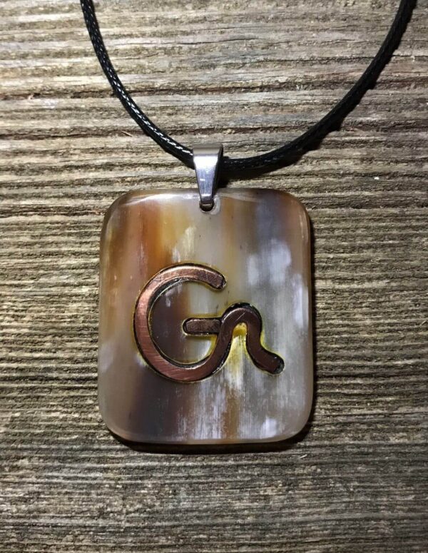 a square pendant with copper inlay