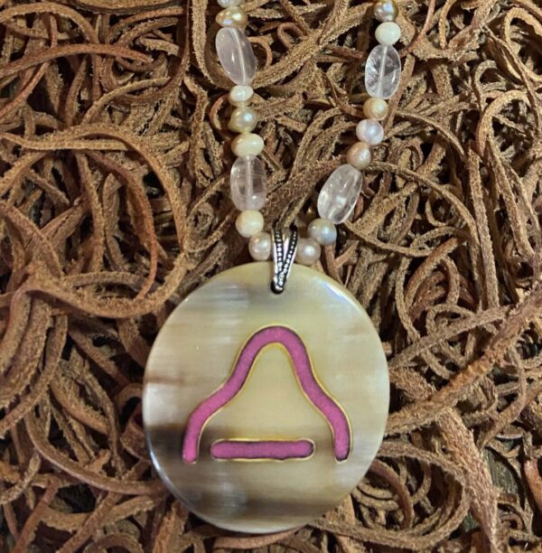 a light color cow horn pendant with inlay