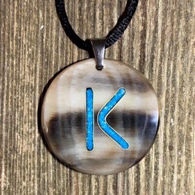 a round cow horn pendant with turquoise inlay