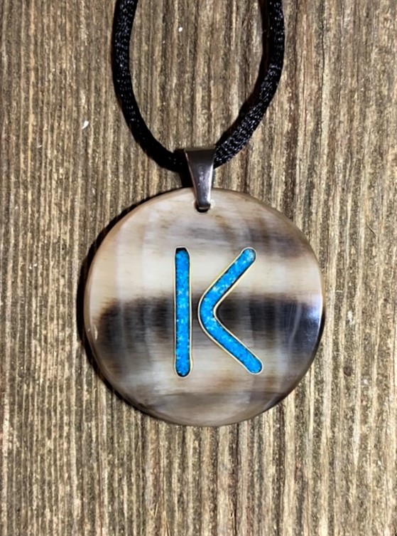 a round cow horn pendant with turquoise inlay