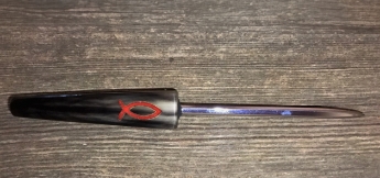 a dark cow horn letter opener with a red inlay