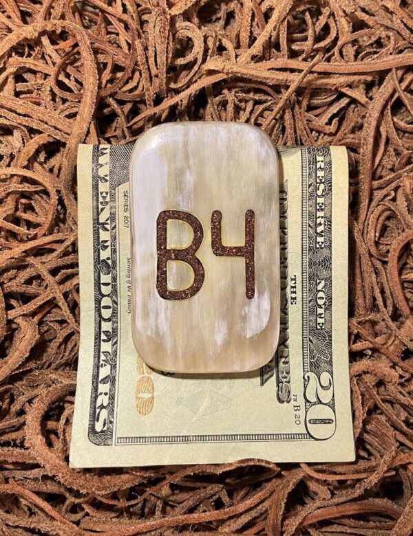 a light cow horn money clip with copper inlay